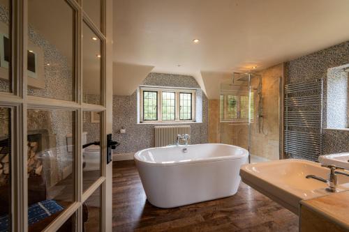 a large bathroom with a tub and a sink at The Lamb Inn in Burford