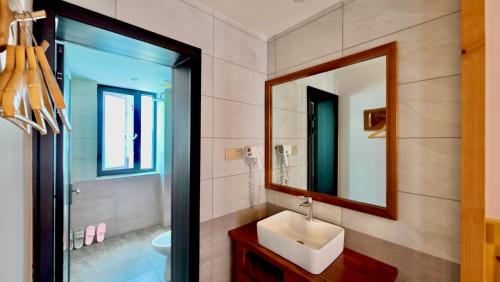 a bathroom with a sink and a mirror at Yesuhanshe Homestay in Zhangjiajie