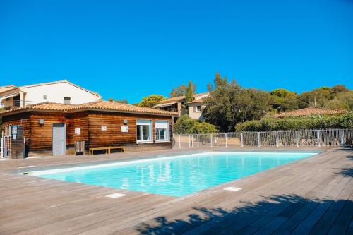 a swimming pool in front of a house at Pinarello - Les hameaux 1 in Sainte-Lucie de Porto-Vecchio