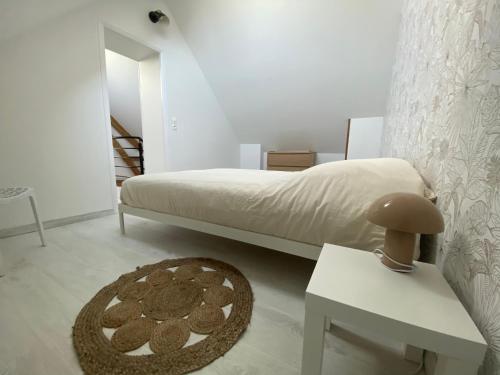 una camera da letto con un letto, un tavolo e uno sgabello di La P'tite Maison a Saint-Julien-sur-Cher