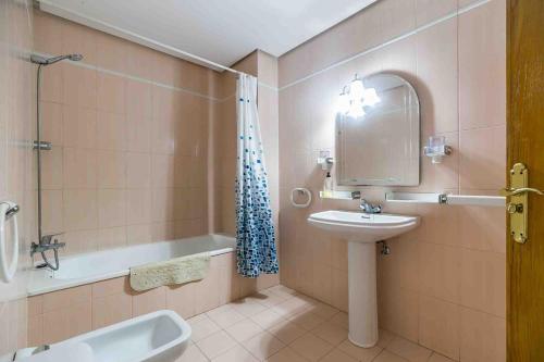 a bathroom with a sink and a mirror and a tub at Apartamento Calypso in Las Lagunas Mijas