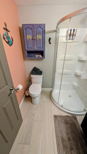 a bathroom with a toilet and a glass shower at Merritt Island hideaway in Merritt Island