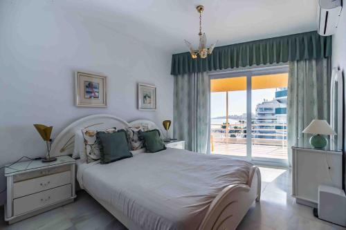 a bedroom with a large bed and a large window at Apartamento Calypso in Las Lagunas Mijas