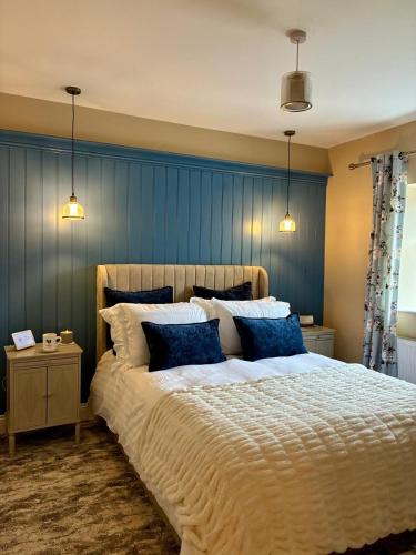 a bedroom with a large bed with blue walls at LAKE VIEW Luxury Apartment in Dunfanaghy