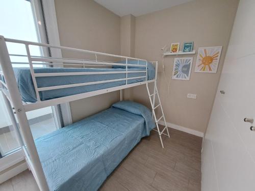 a bunk bed in a small room with a ladder at Paraiso Duna 2 Beach Views in Morche