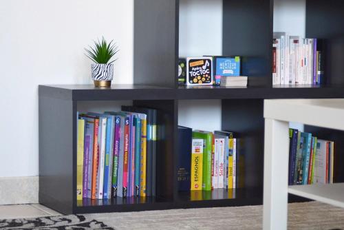 una libreria piena di libri e una pianta in vaso di La Kasa a Mainvilliers