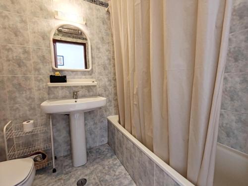 een badkamer met een wastafel en een douchegordijn bij 8 1 Figueirinhas - Casas & Papéis in Armação de Pêra