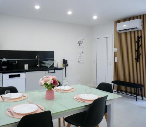 a dining room with a table and chairs and a kitchen at Casa das Abelhas in Arcos de Valdevez