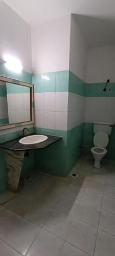 a bathroom with a sink and a toilet at Hotel Swaagat in Agra