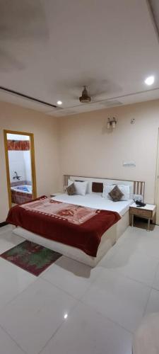 a bedroom with a large bed with a red blanket at Hotel Swaagat in Agra