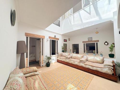 a living room with a long couch in a room at Riad Lailouza in Essaouira