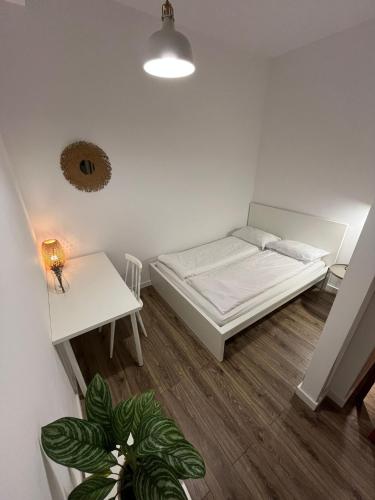 a small room with a bed and a table at Windows to the City Stylish Apartment in Poznań