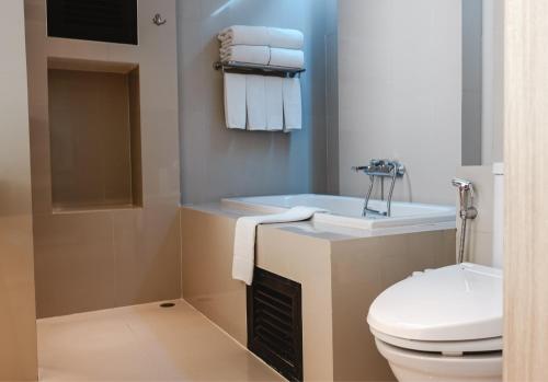 a bathroom with a toilet and a sink and a tub at The Lantern Resorts Patong - SHA Extra Plus in Patong Beach