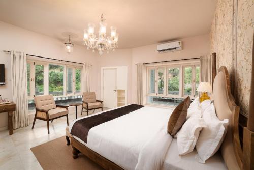 a bedroom with a large bed and a chandelier at Victoria Mansion - A Signature Collection by HST Hotels in Udaipur