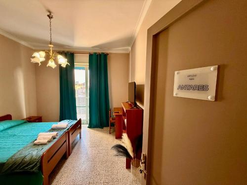 a bedroom with a bed and a window with green curtains at VIMAVÌ Rooms & Apartment in Catania