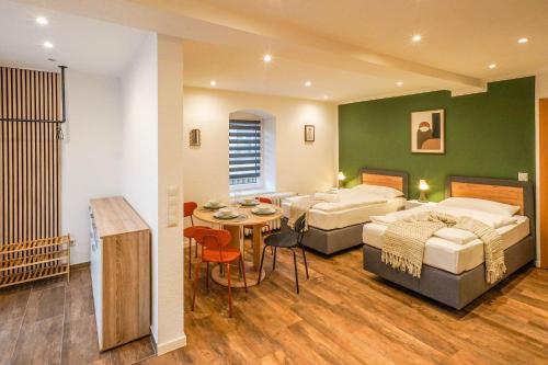 a bedroom with two beds and a table with a dining room at BaLa Suites Apartment House in Bad Lausick