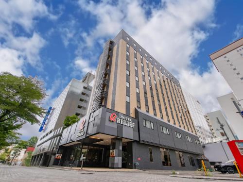 a building with a sign on the front of it at HOTEL RELIEF Sapporo Susukino in Sapporo