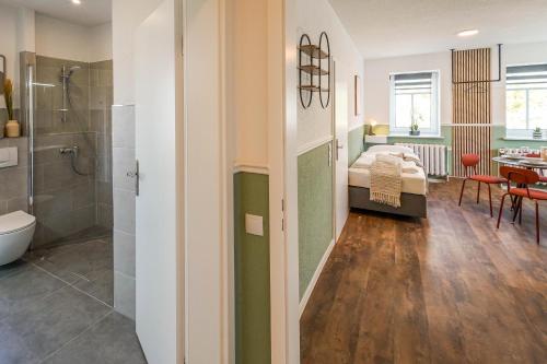 a bedroom with a bed and a bathroom with a shower at BaLa Suites Apartment House in Bad Lausick