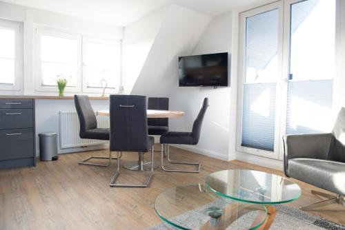 un soggiorno con tavolo e sedie di Deichstübchen oben a Norddeich