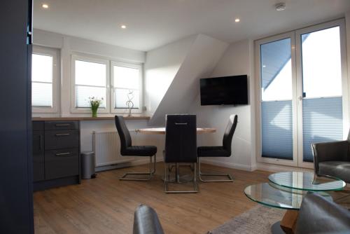 un soggiorno con tavolo e sedie di Deichstübchen oben a Norddeich