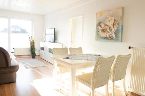 a living room with a white table and chairs at Deichnähe F in Norddeich