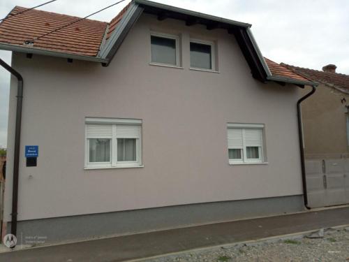 a white house with three windows at Apartman Turić Vinkovci in Vinkovci