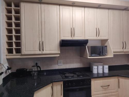 a kitchen with white cabinets and a black counter top at Santana Resort 401 in Margate