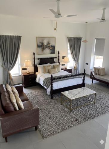 a large bedroom with a bed and a couch at Privé Residence in Rāmnagar