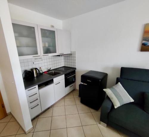 a kitchen with a couch and a sink and a stove at Seemöwe in Binz