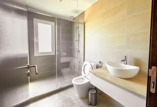Un baño con lavabo, inodoro y ducha. en Linaa, en Libreville
