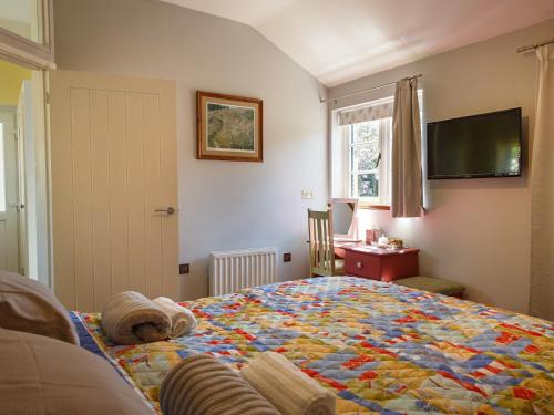 a bedroom with a bed with a quilt on it at 1 Bed in Whissonsett 77597 in Whissonsett