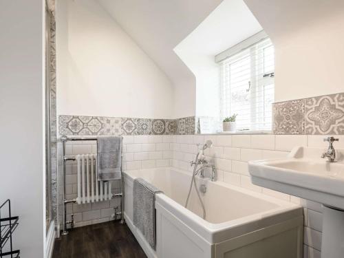 a white bathroom with a tub and a sink at 3 Bed in Thornton-Le-Dale 82856 in Thornton Dale