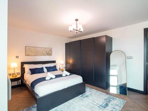 a bedroom with a large bed and a mirror at Stylish 2BR City-Centre Apart Near LGI & Leeds Uni Sleeps 6 in Leeds