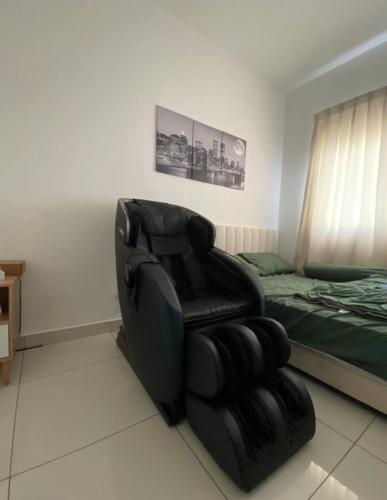 a bedroom with a black chair and a bed at Homestay,Gaming in Shah Alam