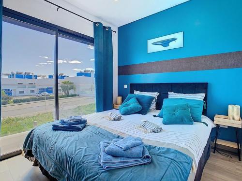 a blue bedroom with a large bed with towels on it at Casa Launa Fuseta in Fuzeta