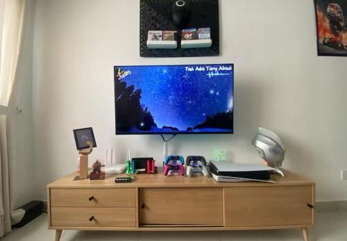 a wooden desk with a tv on a wall at Homestay,Gaming in Shah Alam