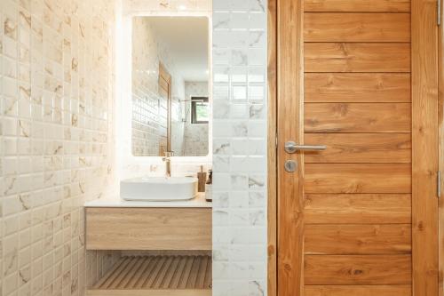 a bathroom with a sink and a wooden door at Staylar Sunrise Villas - Chaweng Noi, Koh Samui in Amphoe Koh Samui