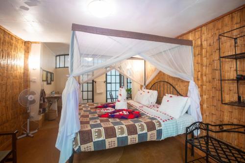 a bedroom with a bed with a canopy at Octagon Lodge in Karatu