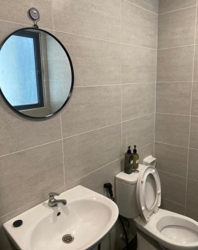 a bathroom with a sink and a mirror and a toilet at Homestay,Gaming in Shah Alam