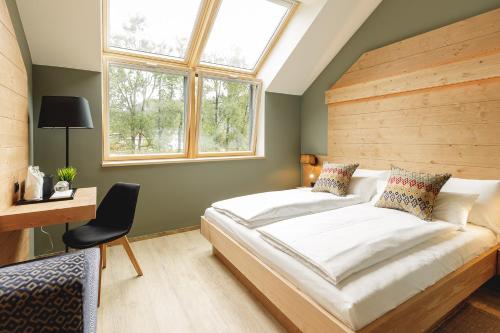 a bedroom with a large bed with a wooden headboard at Boutique Hotel Sunrose 7 - Gourmet & SPA in Bohinj