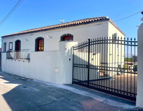 a white house with a gate in front of it at Casa e Cori in Santa Tecla