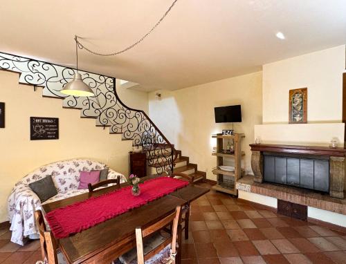 a living room with a table and a piano at CLAUDIA VACANZA TOSCANA - Appartamento Nocciolo- 10 min da Siena in Malignano