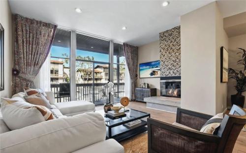 a living room with a white couch and a fireplace at Waterfront Three-Bedroom Condo with Great Views in Naples