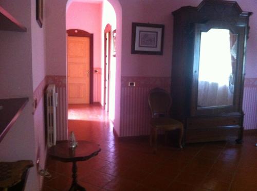 a hallway with pink walls and a door and a table at La dimora dei 5 sensi in Faiano