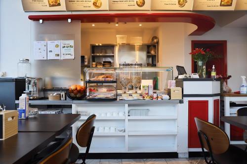 a restaurant with a counter with food on it at VISIONAPARTMENTS Militärstrasse - contactless check-in in Zürich