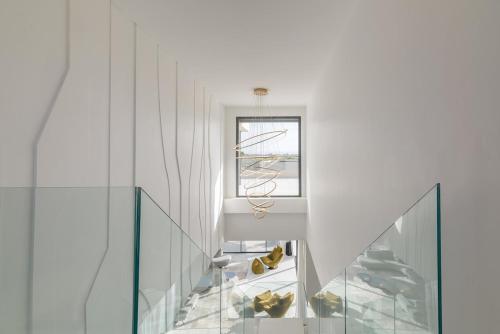 a white room with a glass staircase and a window at Villa Sofya - Roche Bobois Design & HD Wifi in Marrakesh