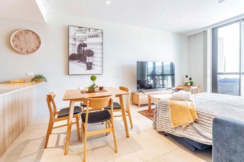 a living room with a table and a dining room at 412 on CODA Oasis with Mountain View in Coffs Harbour