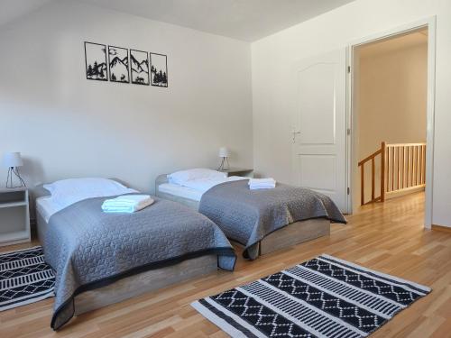 a bedroom with two beds and a hallway with a door at The Other House in Miercurea-Ciuc