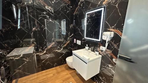 a black marble bathroom with a toilet and a sink at LiEl Holiday in Vlorë