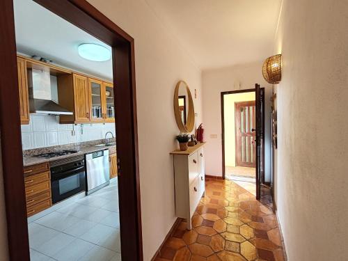 a kitchen with wooden cabinets and a mirror at 61 Casa Pitta Manau - Casas & Papéis in Porches
